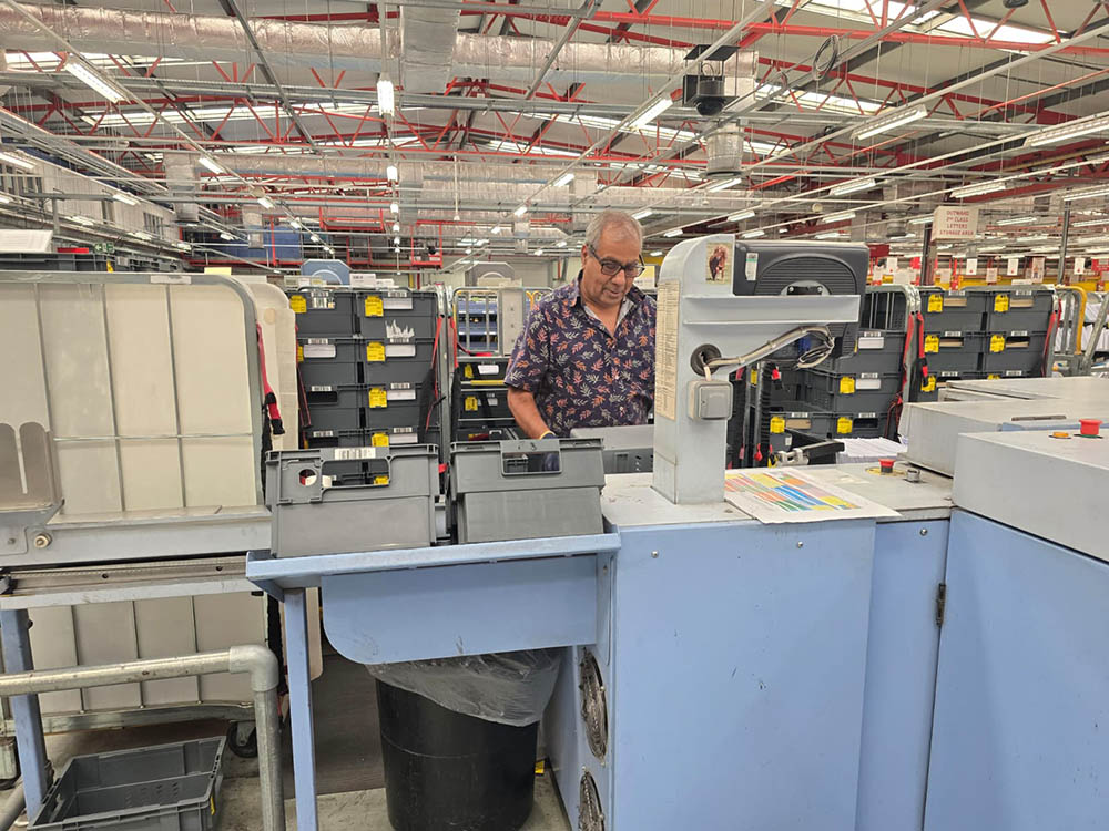 A man operating a machine in the mail centre.