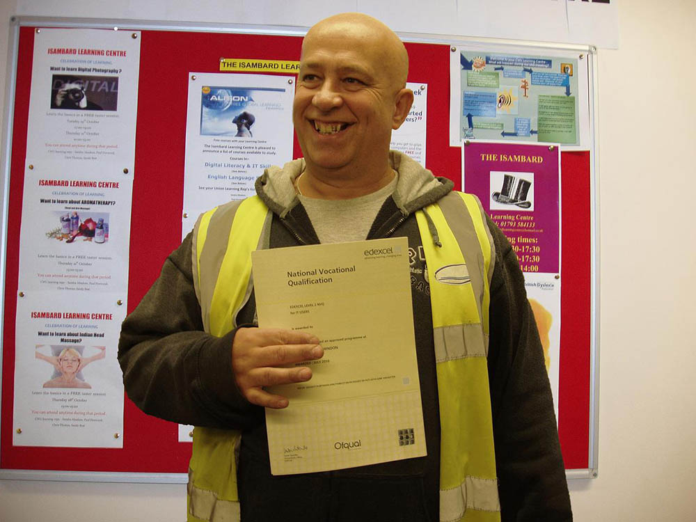 A man holding up a certificate titled: 'National Vocational Qualification'