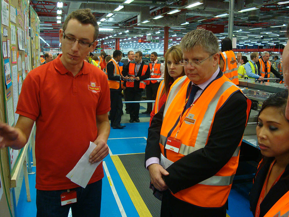 Postal workers in uniform at the mail centre.