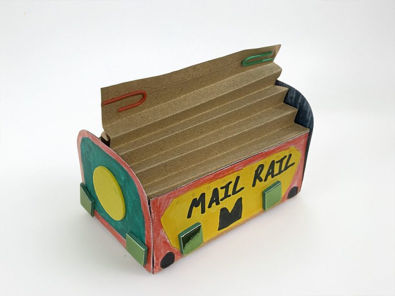 A colourful red, yellow and green paper model of a Mail Rail York trolley.