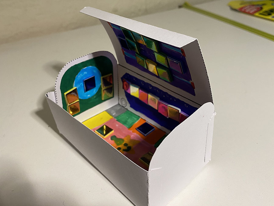 A colourful paper model of a Mail Rail York trolley, decorated on the inside.
