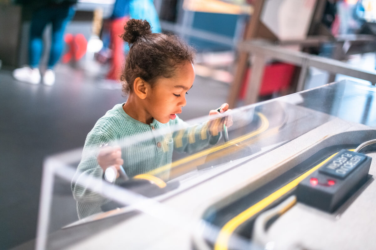 A child playing with an interactive museum exhibit.